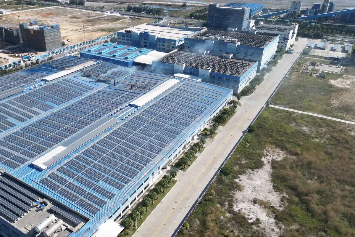 Aerial view of rooftop solar arrays covering an industrial manufacturing complex