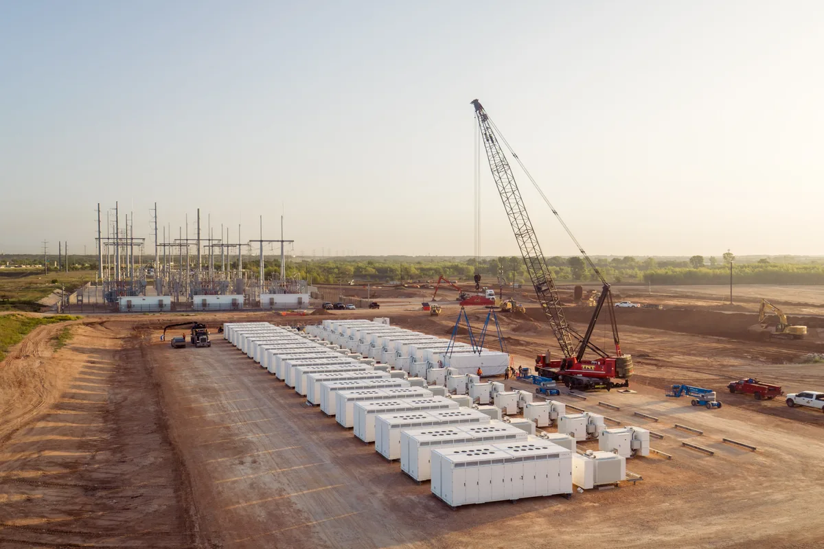 Row of containerized ESS units craned onto prepared pads at a utility-scale site