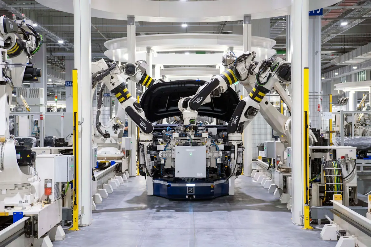 Robotic arms assembling a vehicle body on an automated LSEV production line